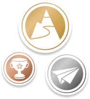 Drei kreisförmige Abzeichen in Gold, Silber und Bronze mit Symbolen von Berg, Papierflieger und Pokal.