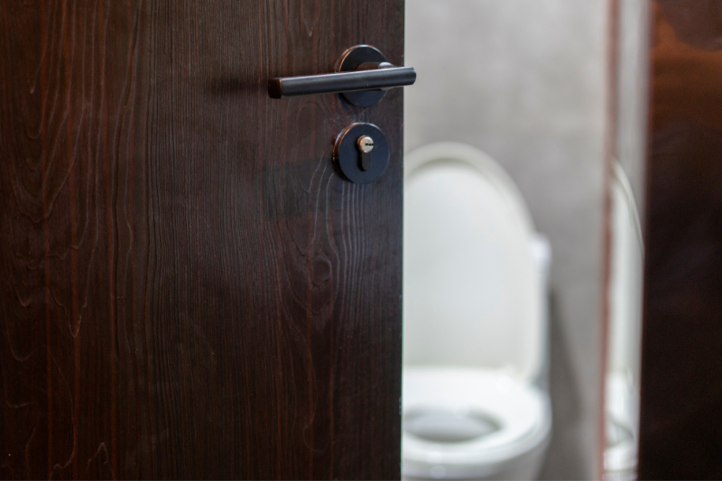 Foto einer halb geöffneten Tür hinter der ein WC zu sehen ist